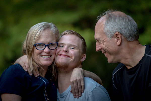 Glueckliche Familie - Mutter, Vater und Sohn mit geistiger Behinderung